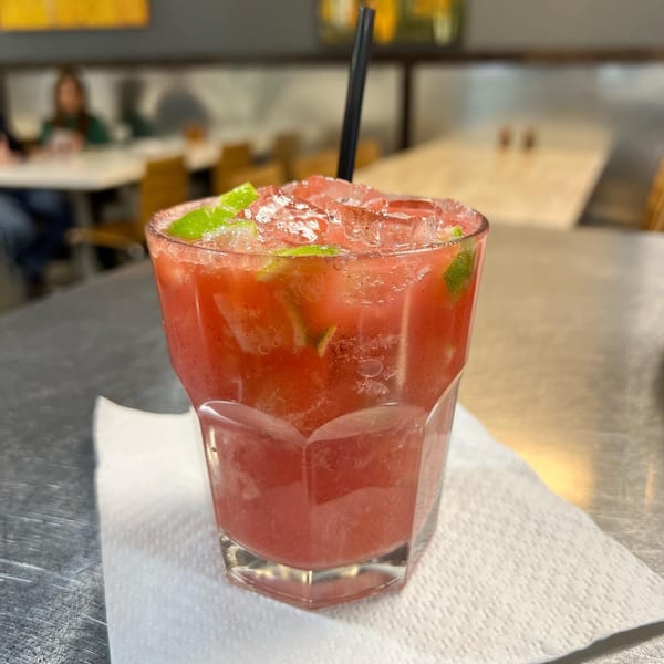 Aroma do Brazil's red caipirinha cocktail with lime and ice, on a white napkin.